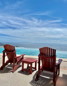 2 wooden beach chairs overlooking the ocean